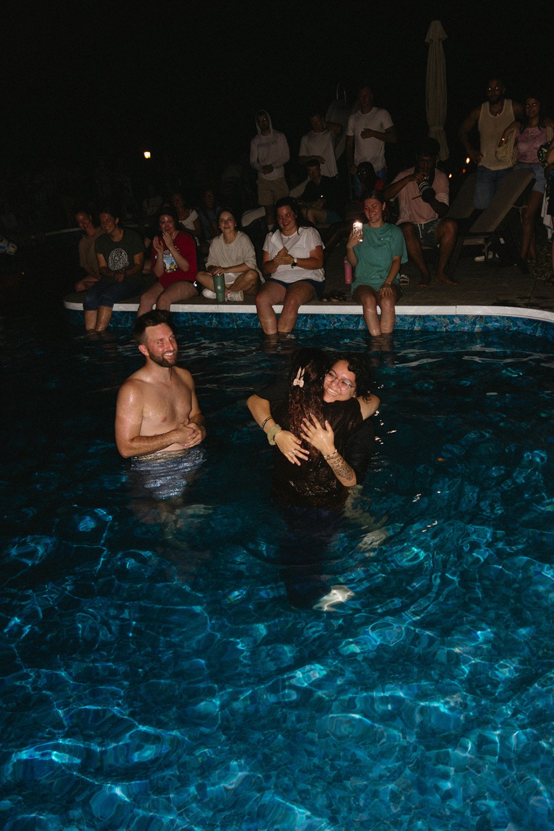 Guests celebrating a pool baptism together at a Sunday S'mores house party