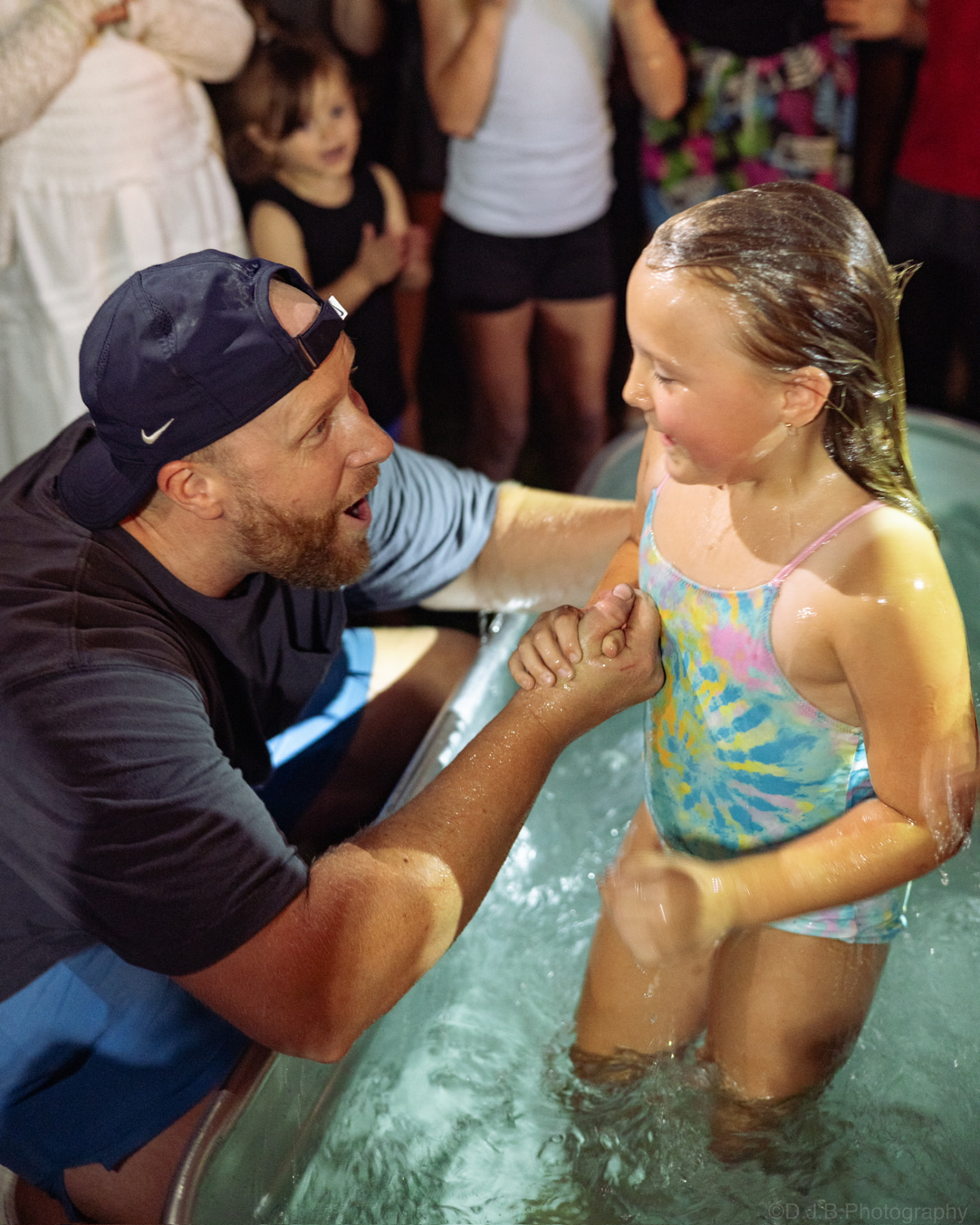 A young girl being baptized at a Sunday S'mores gathering